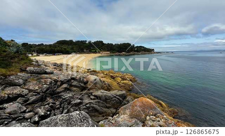 Enjoy a breathtaking beach view with a stunning rocky shoreline and crystal clear waters 126865675
