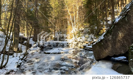 A Serene SnowCovered Stream Flowing Gently Through a Peaceful and Tranquil Forest Setting A Serene SnowCovered Stream Flowing Gently Through a Peaceful and Tranquil Forest Setting 126865737