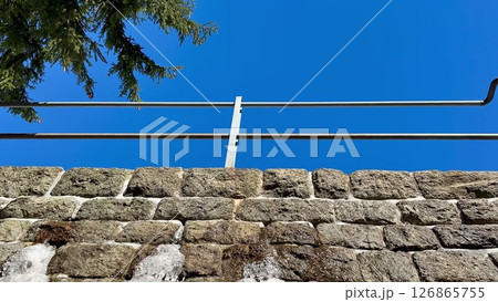 This scenic view shows a charming stone wall under a clear blue sky with elegant railings 126865755