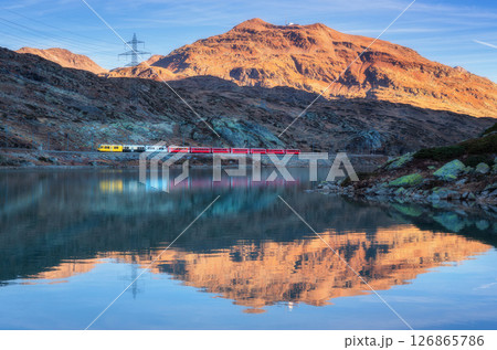 Bernina express train and alpine lake with colorful reflections 126865786