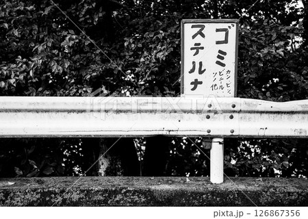 手書きの「ゴミ捨てるな」看板と錆びたガードレール(モノクロ) 手書きの「ゴミ捨てるな」看板と錆びたガードレール(モノクロ) 126867356