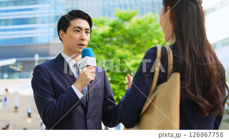 街頭インタビューをする男性レポーター 街頭インタビューをする男性レポーター 126867758