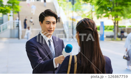 街頭インタビューをする男性レポーター 126867759