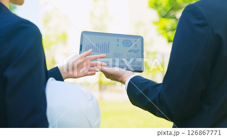 タブレットを見ながら相談する男女作業員 126867771