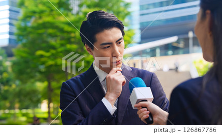 街頭インタビューを受ける男性ビジネスパーソン 126867786