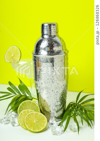 Shaker with fresh lime and glass on light background 126868326