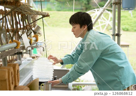 キャンプ場の炊事場でタンクに水を入れる若い男性 キャンプ場の炊事場でタンクに水を入れる若い男性 126868612