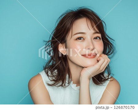 水色背景で微笑む女性の爽やかなポートレート 126870170