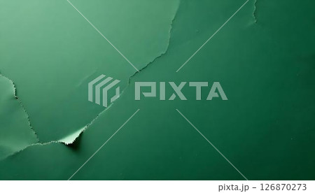 Close-up of a ripped green paper on a textured background, highlighting its detail and connection to Earth Day and recycling 126870273