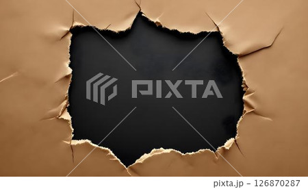 Jagged, torn paper with textured edges set against a black background, revealing intricate details and striking contrast 126870287