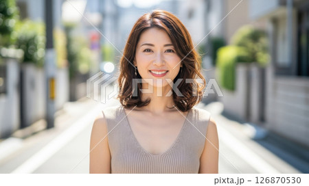明るい日差しの中で笑顔を見せるベージュワンピの女性 126870530