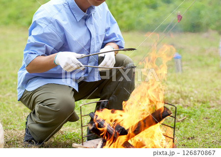 焚き火を調整する男性の手元 焚き火を調整する男性の手元 126870867