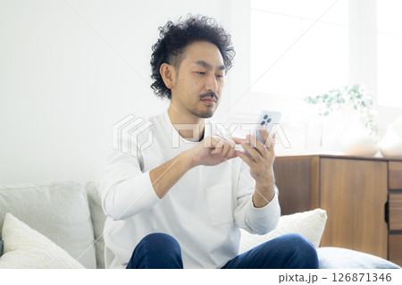 スマホを見て頭を抱える男性 スマホを見て頭を抱える男性 126871346