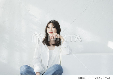 白い壁の前で考え事をする女性 126872798