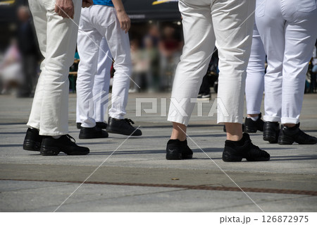 Group of People Wearing White Pants and Black Sneakers in Outdoor Setting 126872975
