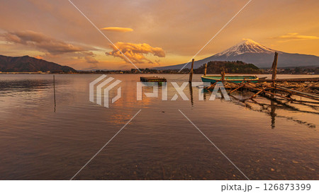 Mt. Fuji at sunset with lake and rocks  in the foreground, from Oishi Park in Kawaguchiko, Japan. Mt. Fuji at sunset with lake and rocks  in the foreground, from Oishi Park in Kawaguchiko, Japan. 126873399