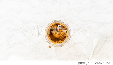Overhead view of a mixing bowl containing fully blended Classic Gingerbread Cookie Dough. The dark, rich brown dough shows a smooth, dense texture, ready to be chilled before rolling and baking into 126874068
