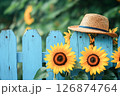 水色のウッドフェンスとひまわりと麦わら帽子 126874764