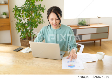 パソコンでホームワーク中のミドル女性 パソコンでホームワーク中のミドル女性 126874979