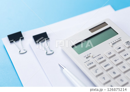 クリップに挟んだ資料と電卓とボールペン 126875214