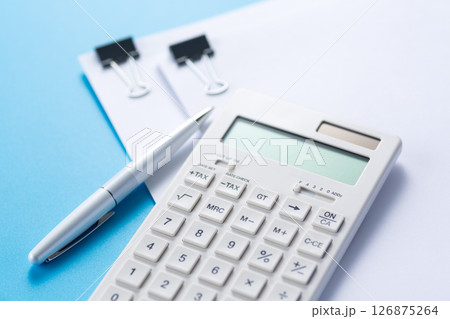 クリップに挟んだ資料と電卓とボールペン 126875264