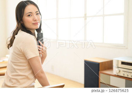 スマホを見ながら音楽を聴く女性 スマホを見ながら音楽を聴く女性 126875625