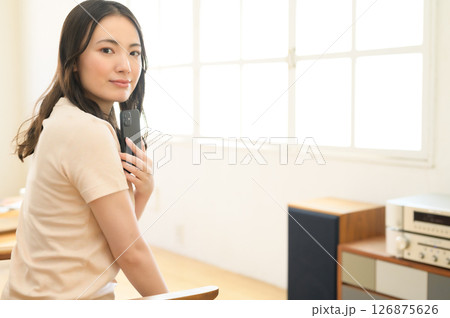 スマホを見ながら音楽を聴く女性 126875626