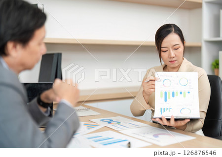 Data Analysis and Business Strategy. Professional presenting financial graphs in a meeting. Data Analysis and Business Strategy. Professional presenting financial graphs in a meeting. 126876546