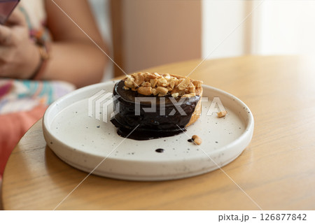 Delectable bakery chocolate delight, topped with crunchy peanuts. 126877842