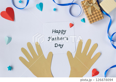 Greeting card composition for Fathers Day with cutout hands, message, and paper tie on blue background, flat lay top view for holiday celebration 126878094