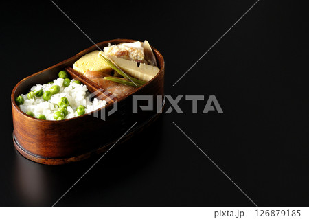 おかずたっぷり豆ご飯弁当を黒背景で撮影 126879185