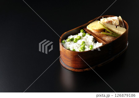 おかずたっぷり豆ご飯弁当を黒背景で撮影 126879186