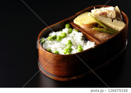 おかずたっぷり豆ご飯弁当を黒背景で撮影 126879188