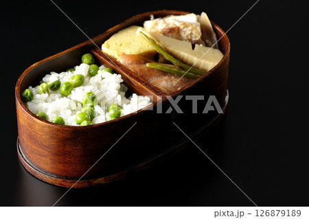 おかずたっぷり豆ご飯弁当を黒背景で撮影 126879189