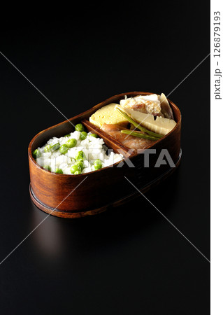 おかずたっぷり豆ご飯弁当を黒背景で撮影 126879193