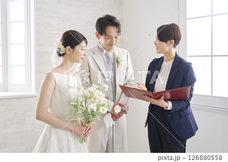 新郎新婦と打ち合わせする結婚式の司会者 126880558