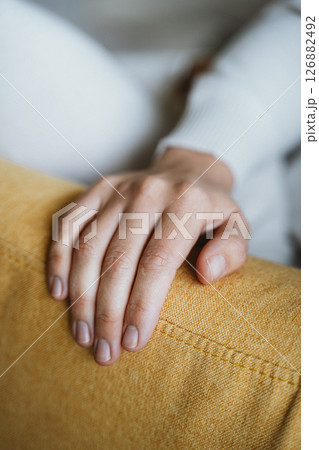 Relaxing Hand Resting on a Comfortable Yellow Couch 126882492