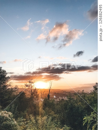 Scenic Sunset over Dense Forest and Distant Mountains 126882495