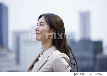 希望を感じさせるスーツ姿の女性と都市風景 126882675