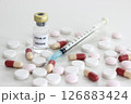 Vial of Covid-19 vaccine, 1 ml plastic syringe with needle and drugs isolated on the white background 126883424