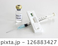 Vial of Covid-19 vaccine, 1 ml plastic syringe with needle and Positive test result of Covid-19 antigen test kit isolated on the white background 126883427