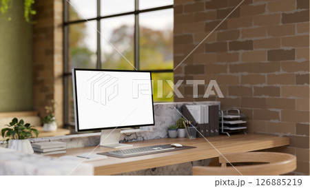 The white screen computer on marble laminate wooden working desk in an office with brick wall. The white screen computer on marble laminate wooden working desk in an office with brick wall. 126885219