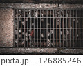 アスファルトの排水口と詰まった小石と落ち葉のディティール 126885246