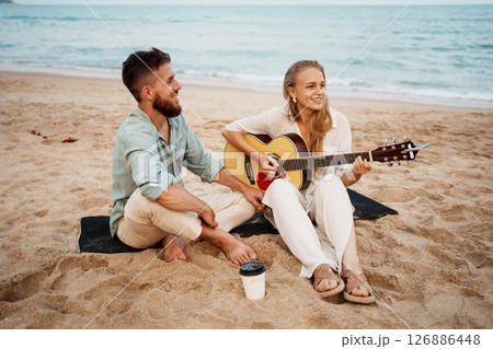 A Happy Couple Enjoying Music Together on the Beautiful Beach During Sunset Moments A Happy Couple Enjoying Music Together on the Beautiful Beach During Sunset Moments 126886448