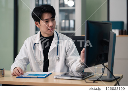Male doctor working on desk with laptop computer and paperwork in the office. Medical and doctor concept. 126888190