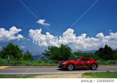 初夏の青山高原　白い雲と青空の下でドライブする赤いフェアレディZ 126888850