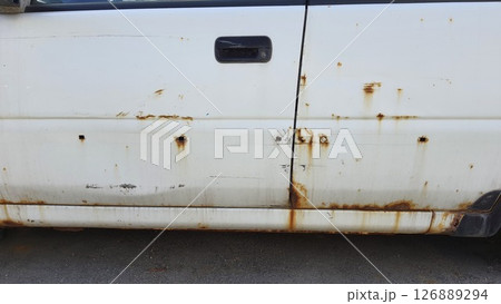 Rusty white car door showing signs of age and corrosion Rusty white car door showing signs of age and corrosion 126889294