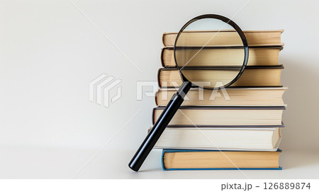Literature, study, science, and business banner featuring a stack of books and a magnifying glass, designed with ample copy space 126889874