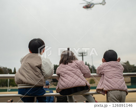 ヘリコプターを見る子供達の後ろ姿 ヘリコプターを見る子供達の後ろ姿 126891146