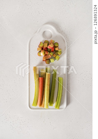 Freshly chopped green rhubarb on white background. Trendy organic food. Ready for cooking. Vegan concept. View from above. 126891324